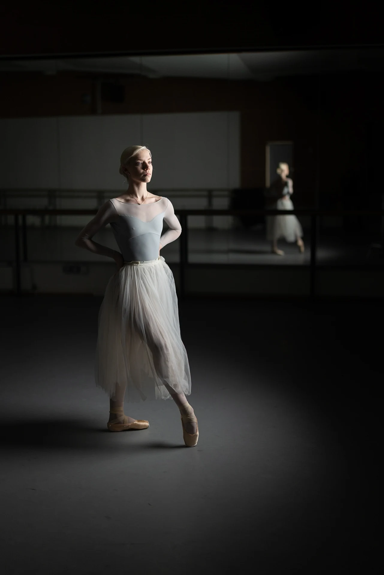 Dancer standing in a pool of studio light