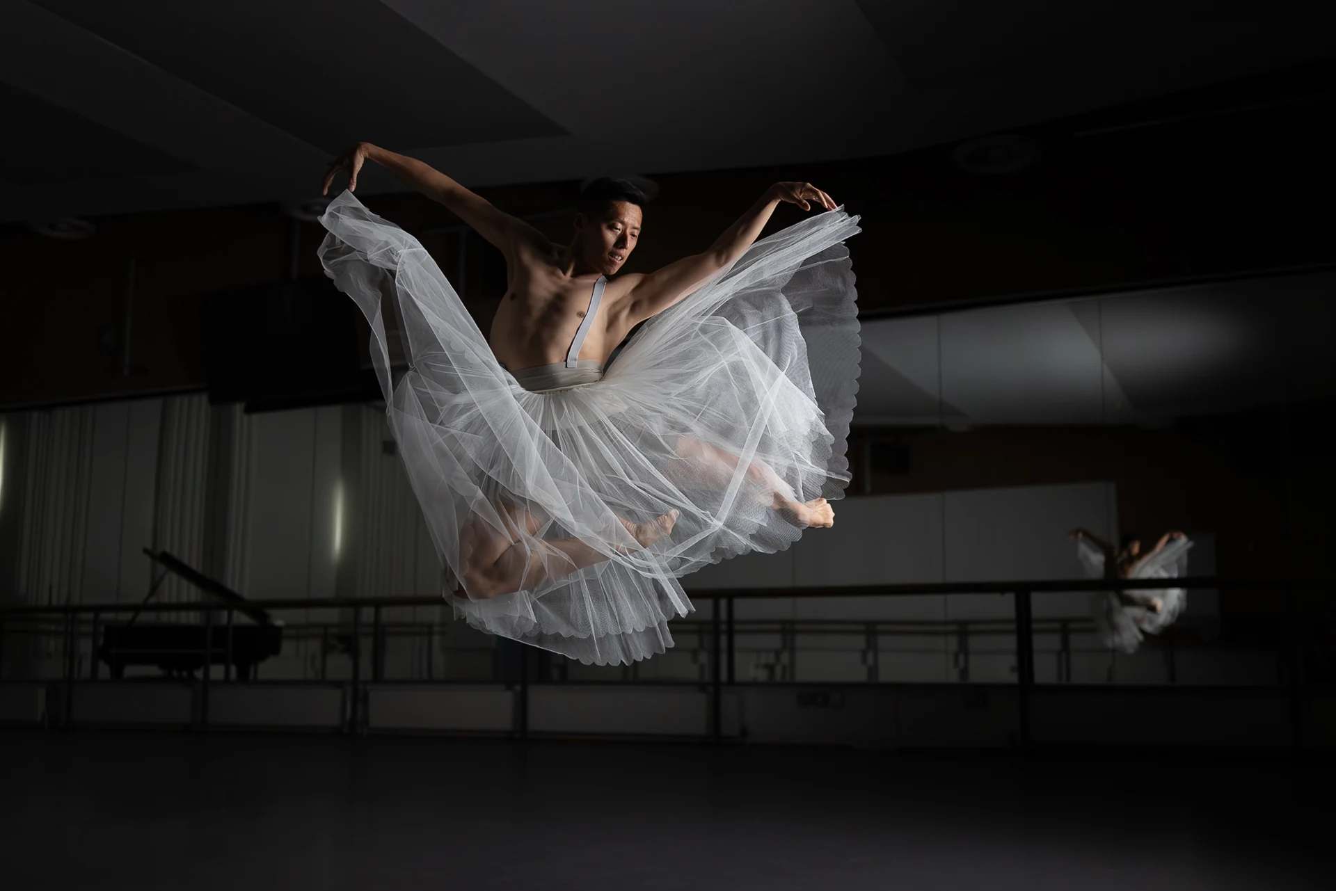 Dancer leaping with white tulle spread wide