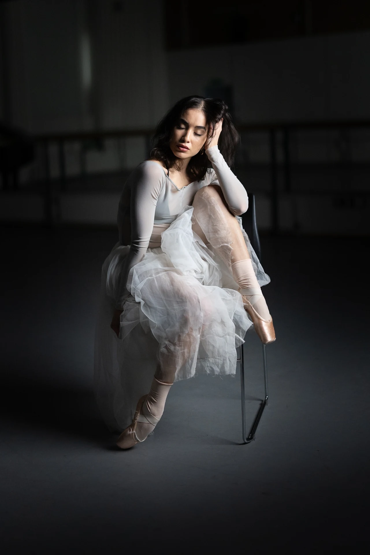 Dancer posing in white tulle in soft light
